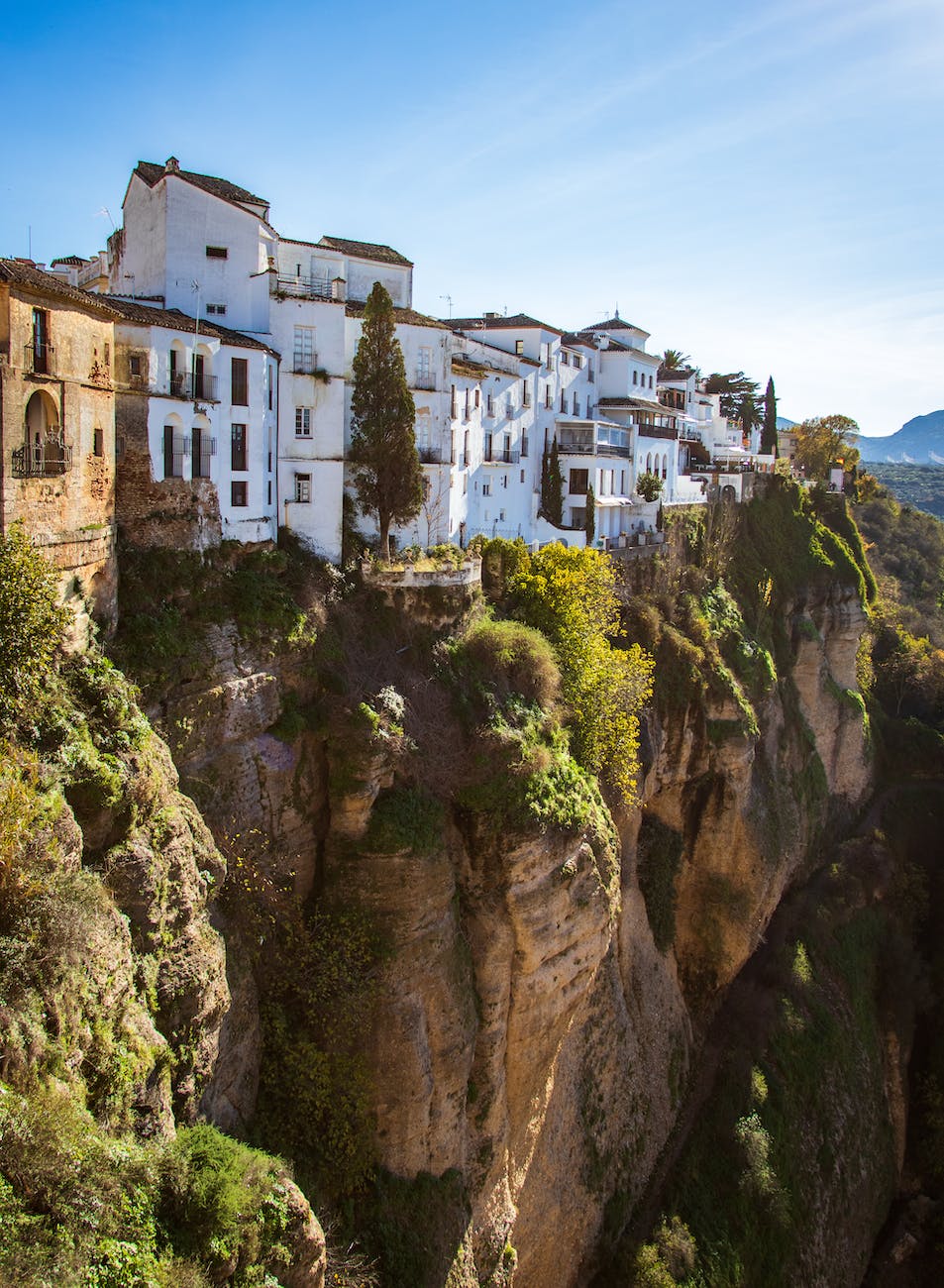 white concrete buildings next to a cliff