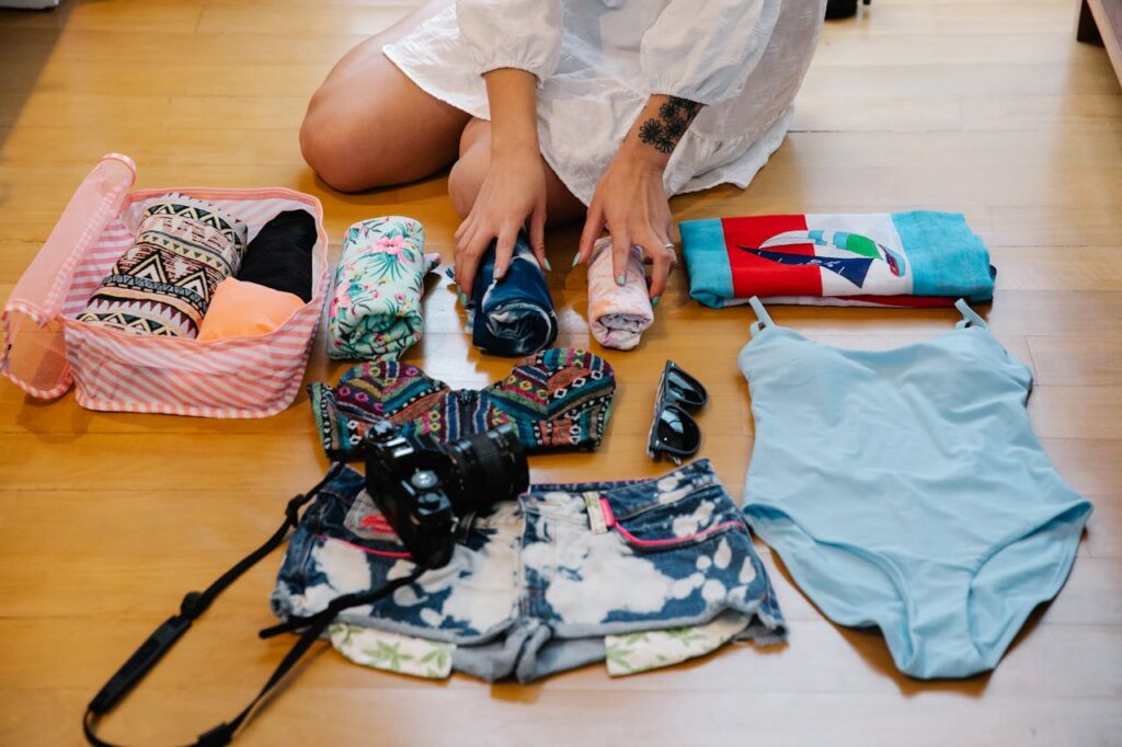 A Person Sitting on a Wooden Floor while Preparing Travel Essentials
