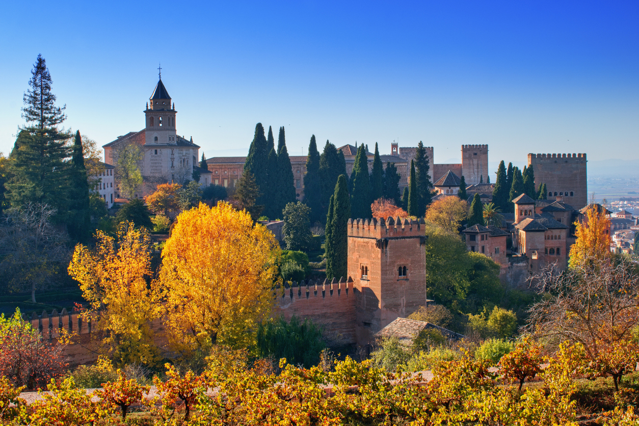 Scenic autumn landscape in Southern Spain with vibrant fall foliage and historic architecture.