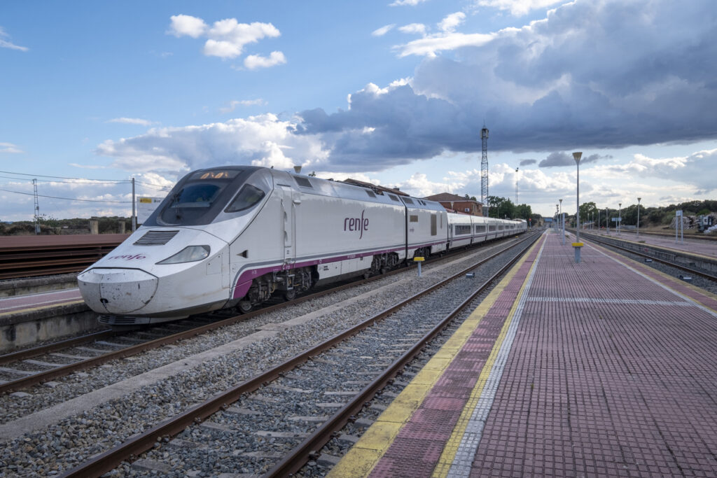 A modern train stopped at the old and still functioning Monfrague or Palazuelo Empalme train station.