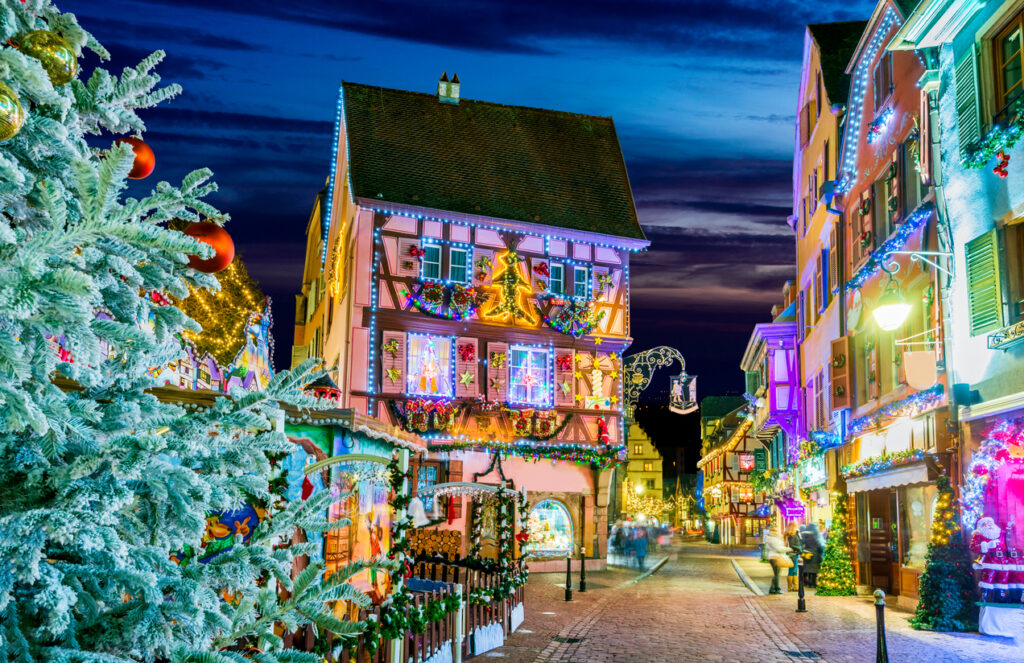 Colmar, Alsace, - A charming European village covered in snow, with festive lights and quaint houses lining cobblestone streets.