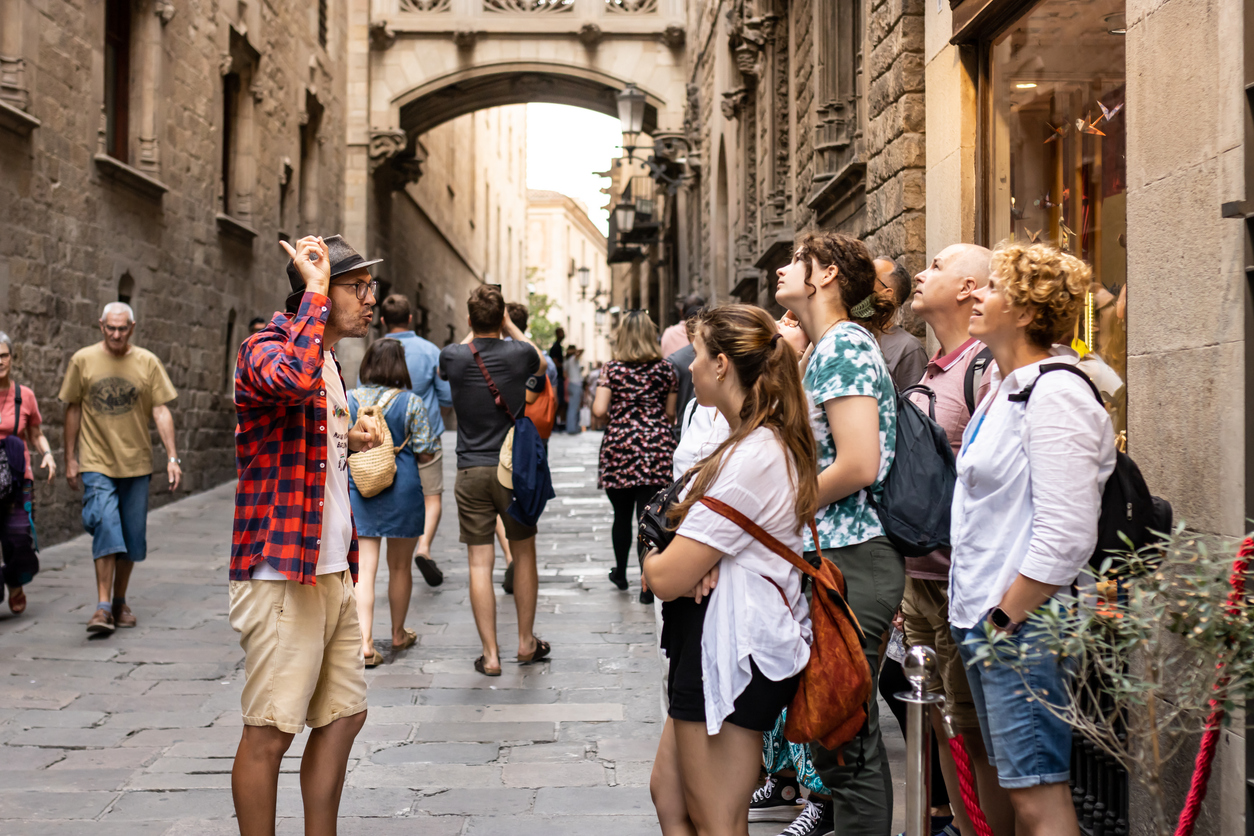 A group of tourists enjoying a guided tour in Spain, walking through a historic city with a guide explaining the landmarks.