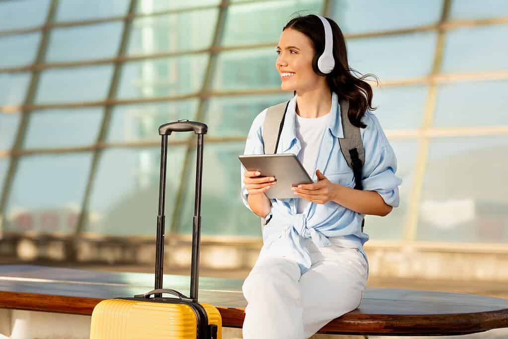 Collection of essential travel gadgets for women, including smart luggage, portable chargers, and noise-canceling headphones.