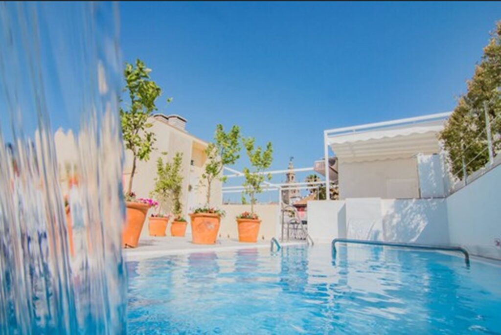 Tranquil pool of a boutique hotel in Seville with potted orange trees - Halo Boutique Hotel Boutique Hotels in Sevilla