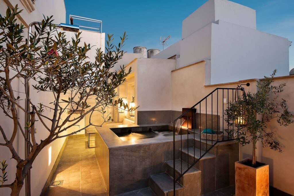 Elegant stone courtyard with antique columns and soft lighting at Corral del Rey Seville