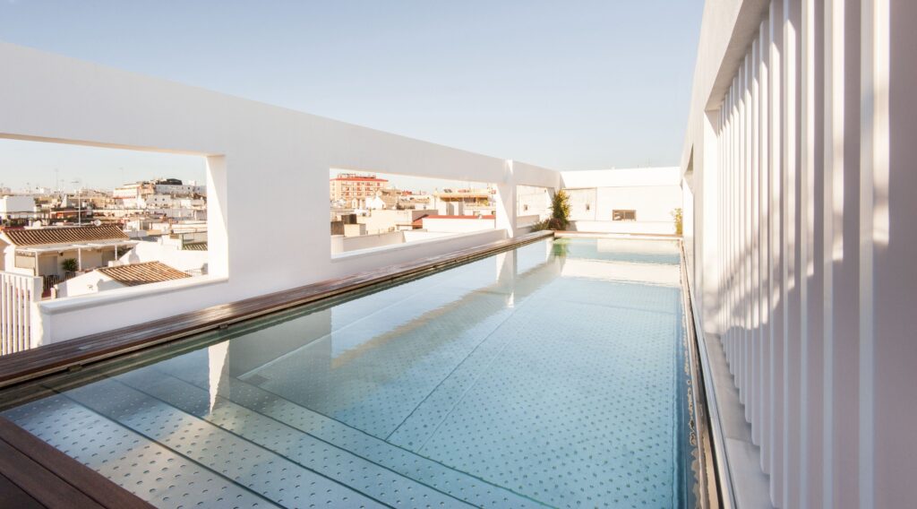 Modern, minimalist suite with tall ceilings and natural light at Mercer Hotel Seville