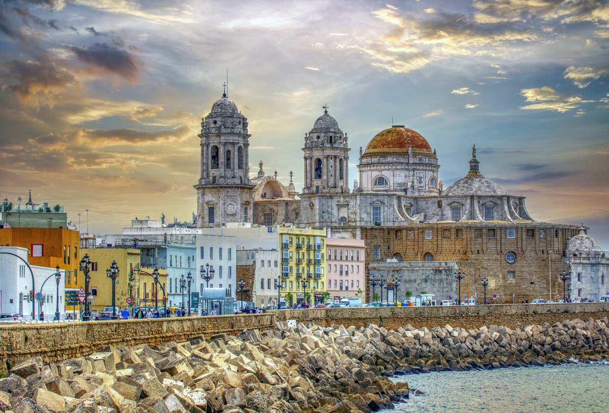 Panoramic view of Cadiz at sunrise with its cathedral, Spain. Sunset view of Cadiz, Spain with ocean and old town - How to spend 3 days in Cadiz, Spain.