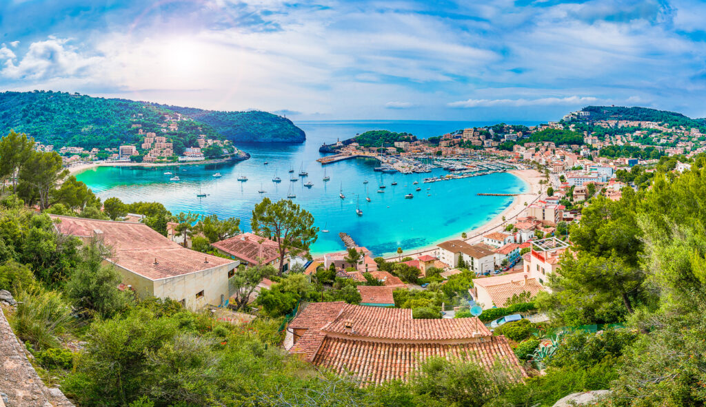 Panoramic view of Porte de Soller, Palma Mallorca, Spain - Coastal view of Mallorca Spain with cliffs, turquoise sea, and terracotta rooftops